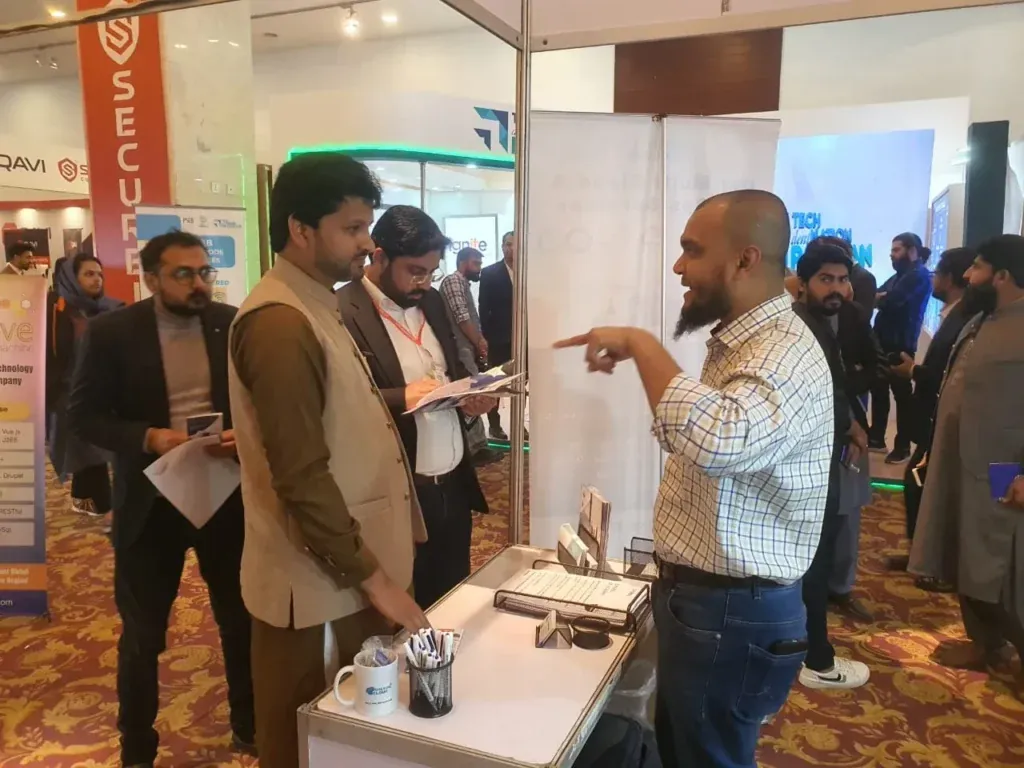 Sherdil team member speaking with visitors at the booth, ITCN Asia 2023