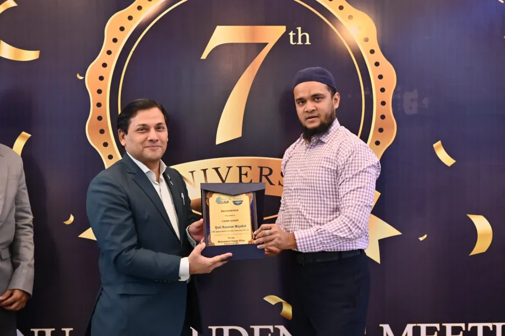 Guest holding a recognition plaque with a Sherdil team member, 2024