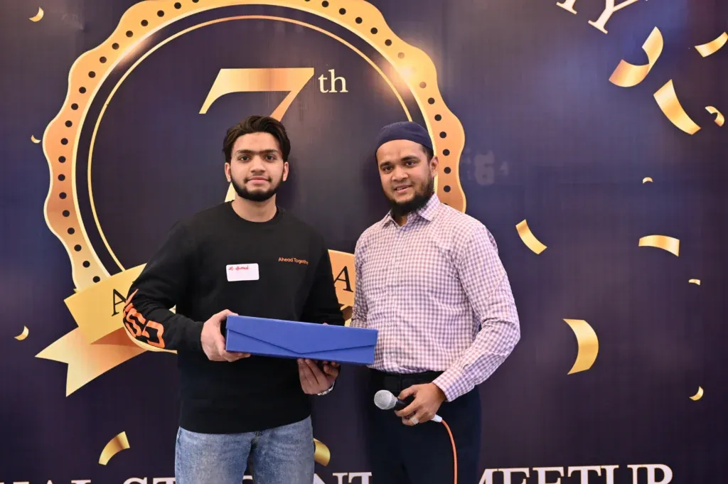 Student receiving a gift box on stage, Sherdil 7th anniversary 2024