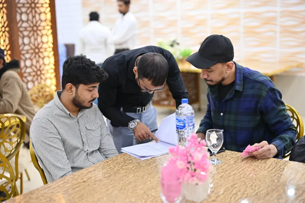 Attendees filling in forms at the Sherdil 7th Anniversary Meetup 2024