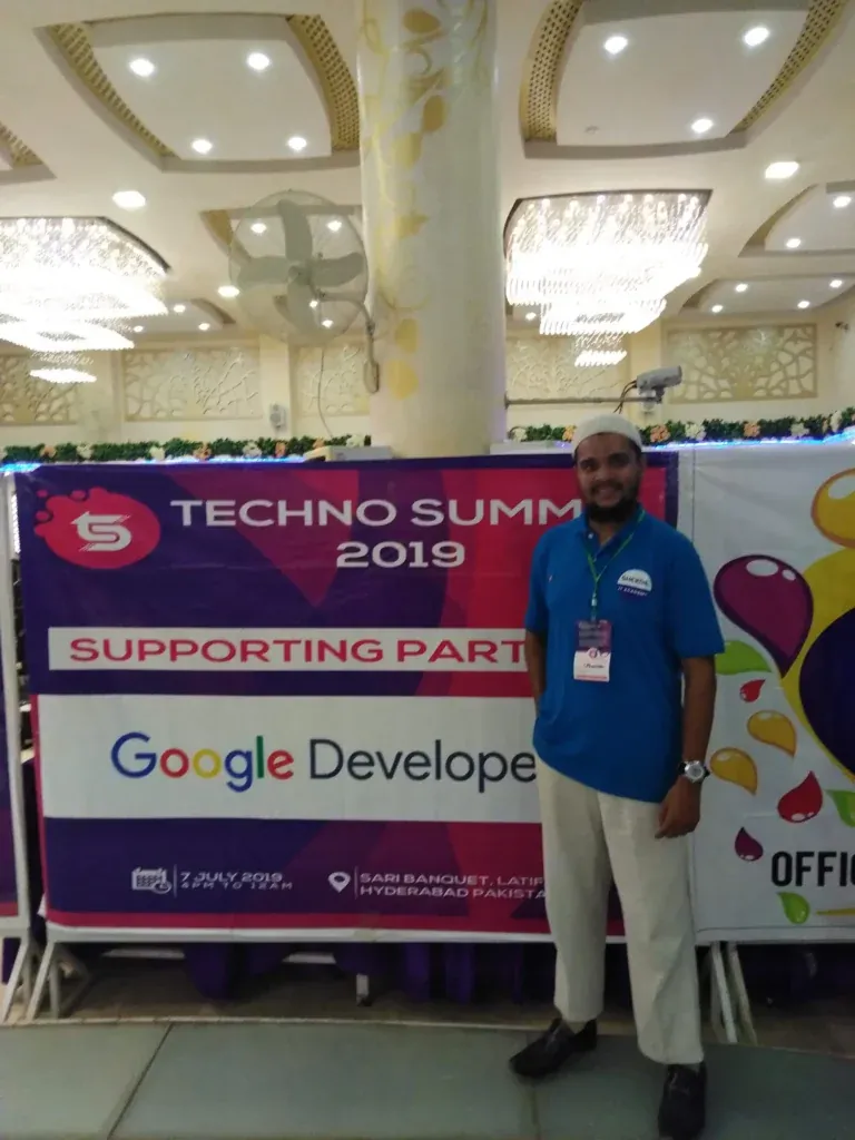 Sherdil team member beside the Techno Summit 2019 banner