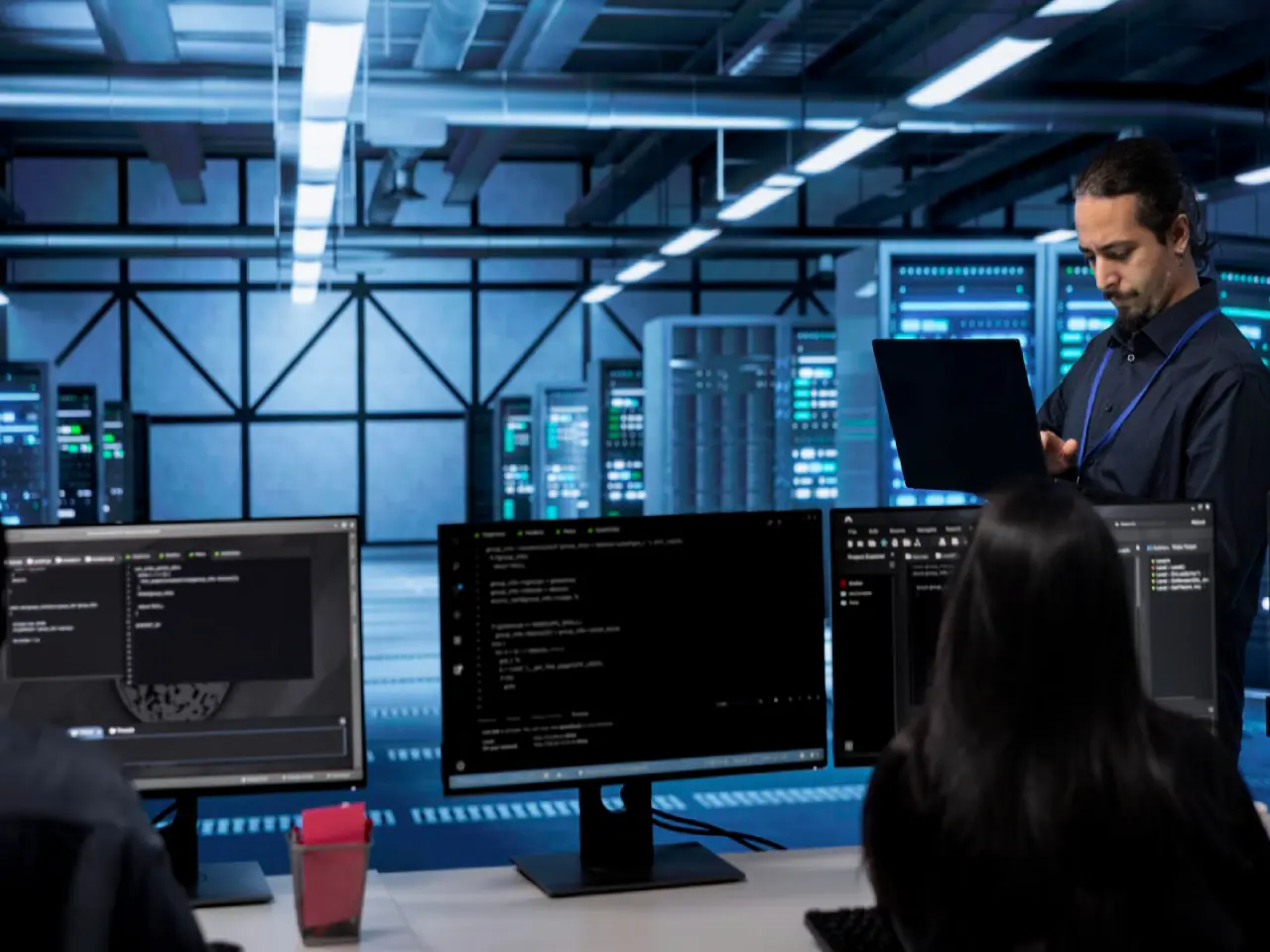 IT professionals working in a modern data center with servers and coding screens, representing multicloud infrastructure strategy for enterprises using AWS, Azure, and Google Cloud in Pakistan.