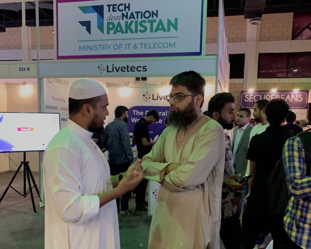 Visitors talking in front of the Tech Destination Pakistan banner, ITCN Asia 2025