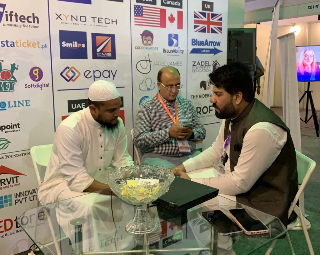 Meeting at the Sherdil booth beside the client logo wall, ITCN Asia 2025 Karachi