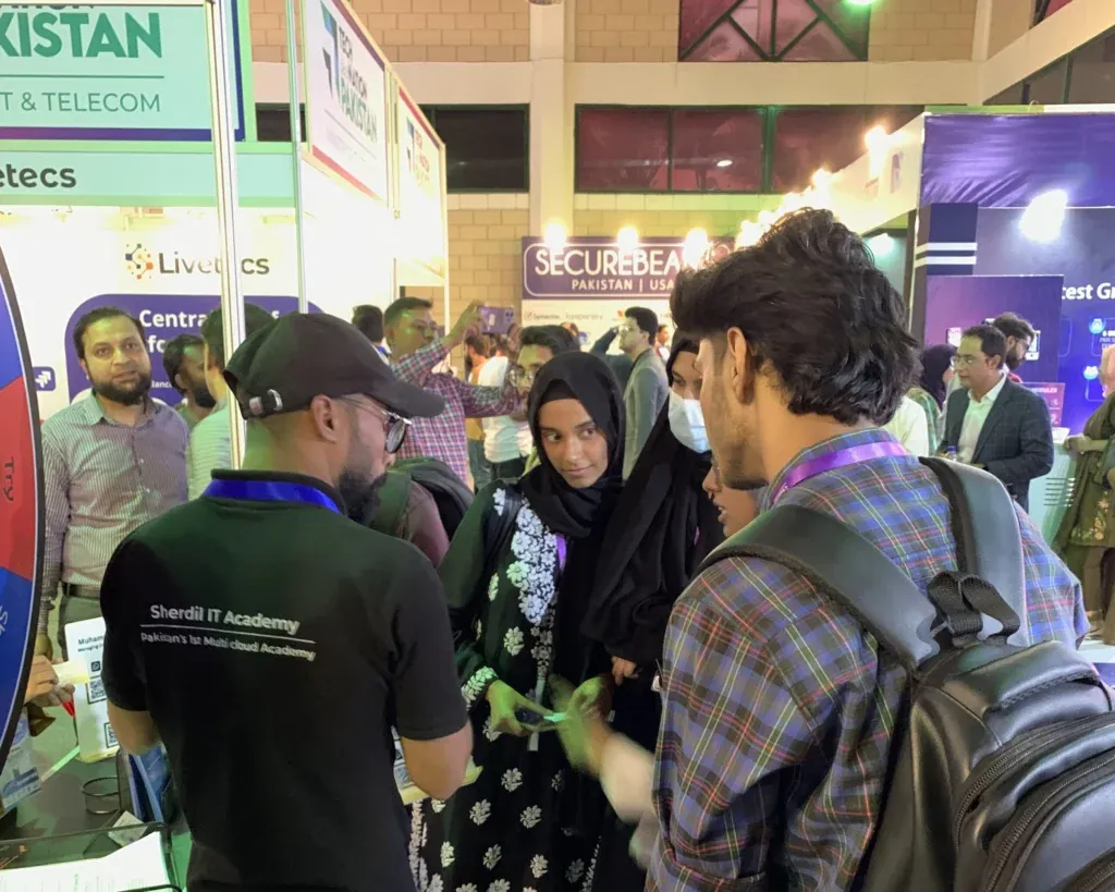 Sherdil team member speaking with visitors at the booth, ITCN Asia 2025