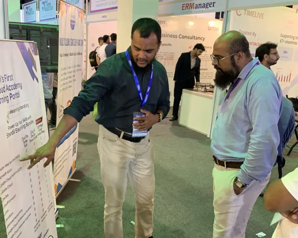 Sherdil team member pointing to a course banner for a visitor, ITCN Asia 2025