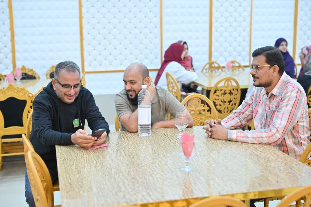 Guests talking at a table during the Sherdil 8th anniversary meetup, 2025