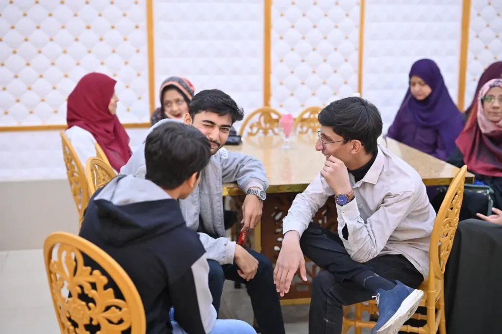 Students chatting at a table during the Sherdil 8th anniversary meetup, 2025