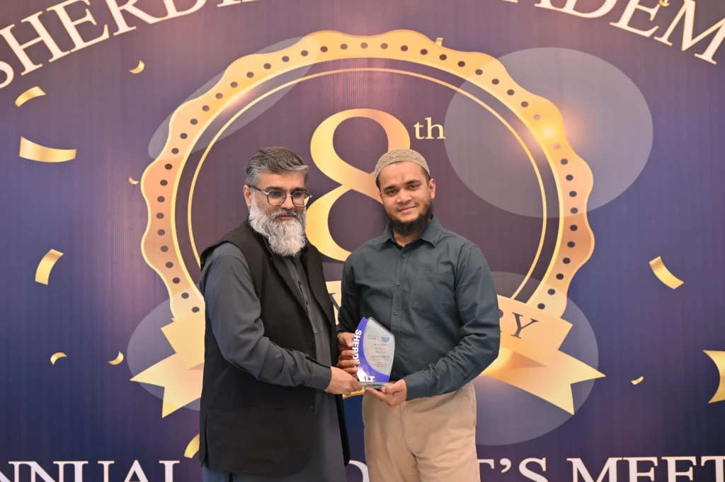 Student receiving an award shield at the Sherdil 8th Anniversary Meetup 2025