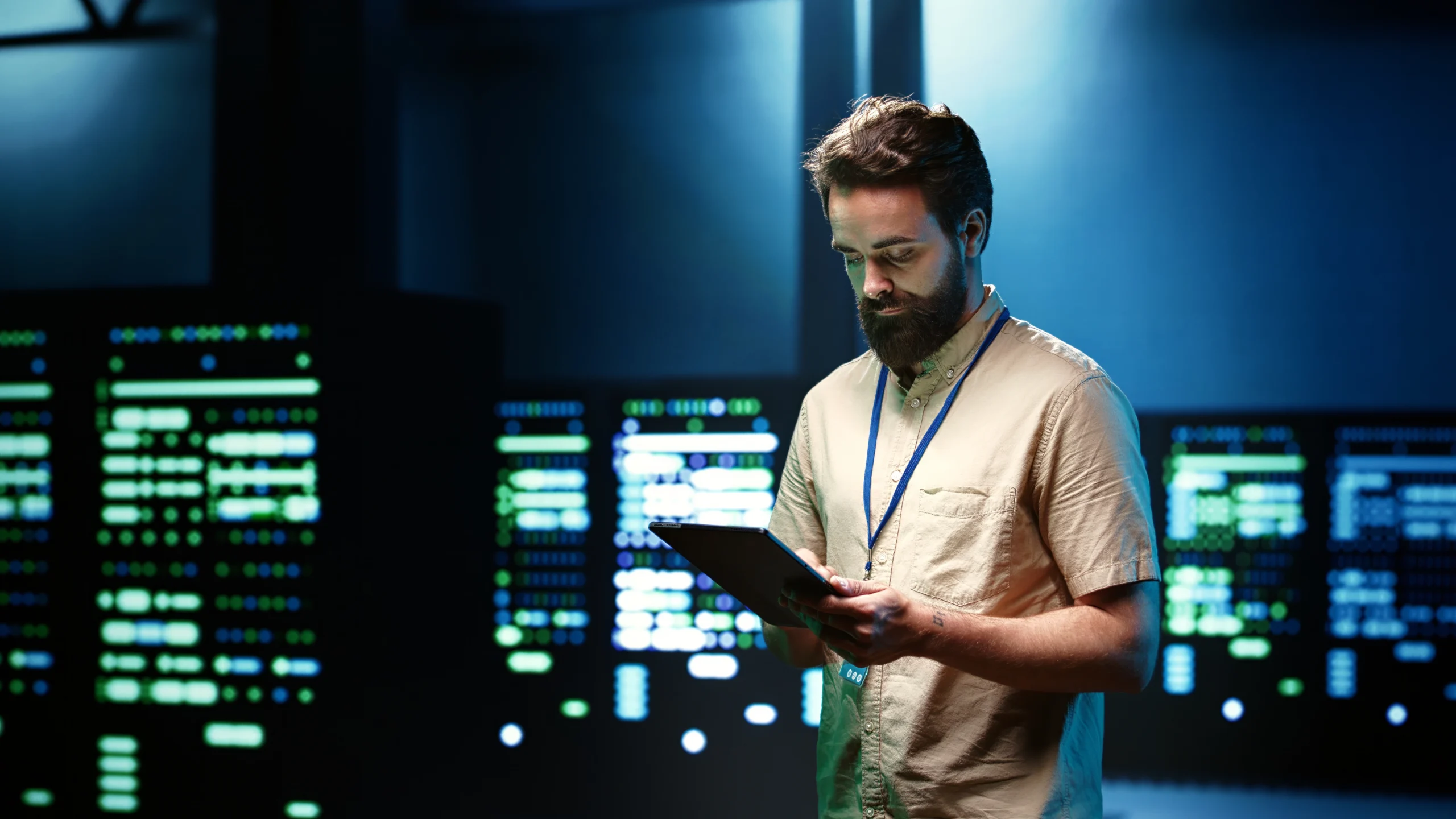 A cloud engineer holding a tablet in a server room surrounded by glowing data screens, representing the skills and confidence needed to negotiate a higher cloud engineer salary in Pakistan.