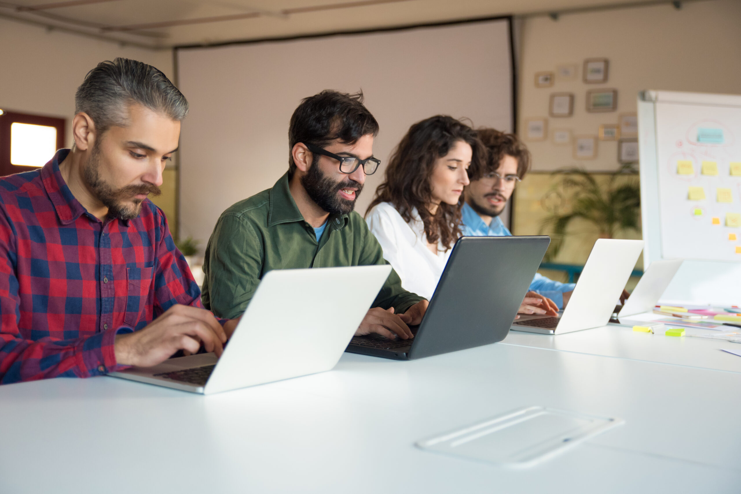 A group of IT learners working on laptops side by side in a casual classroom setting, representing the 15 genuine free IT course options available in Karachi in 2026.