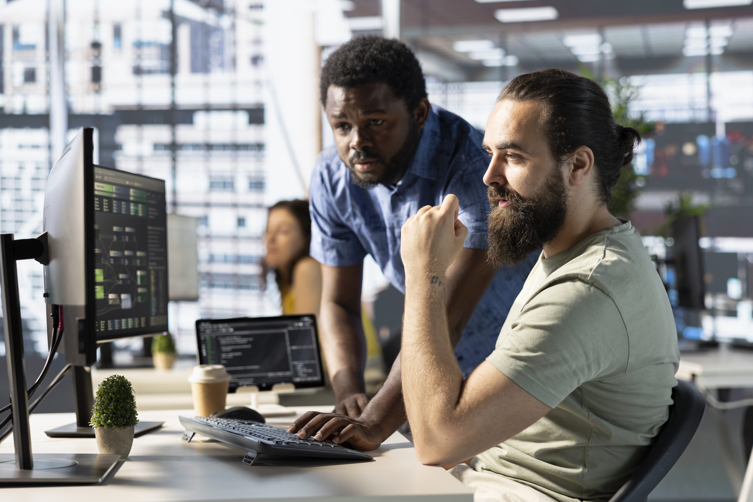 Two DevOps engineers collaborating at a workstation with system dashboards and code on screen in a modern Karachi office, representing how to evaluate and choose the best DevOps course in Karachi in 2026.