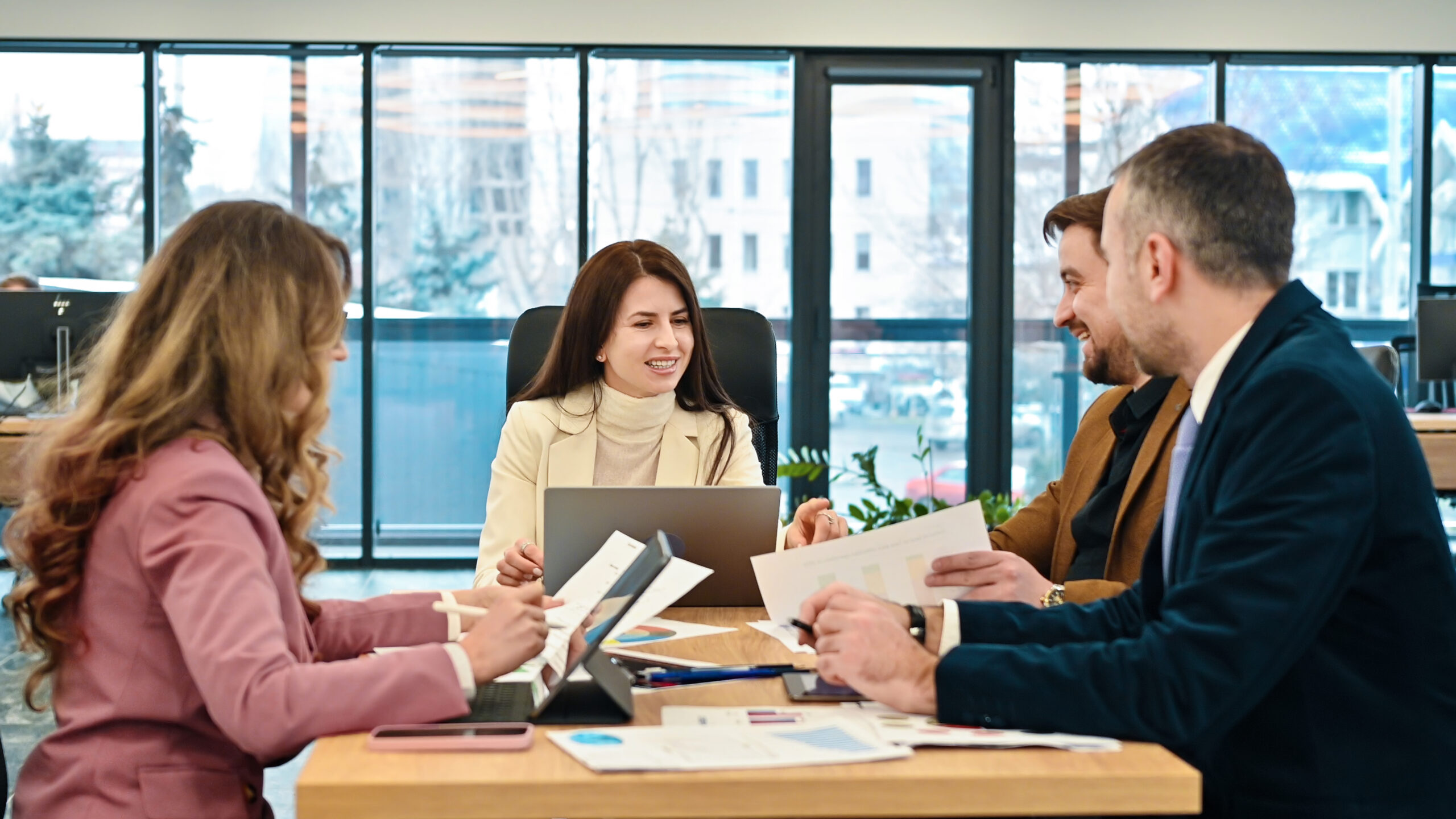 A group of professionals reviewing study materials and reports in a bright modern office, representing candidates preparing to pass the AWS Solutions Architect Associate exam in Pakistan in 2026.