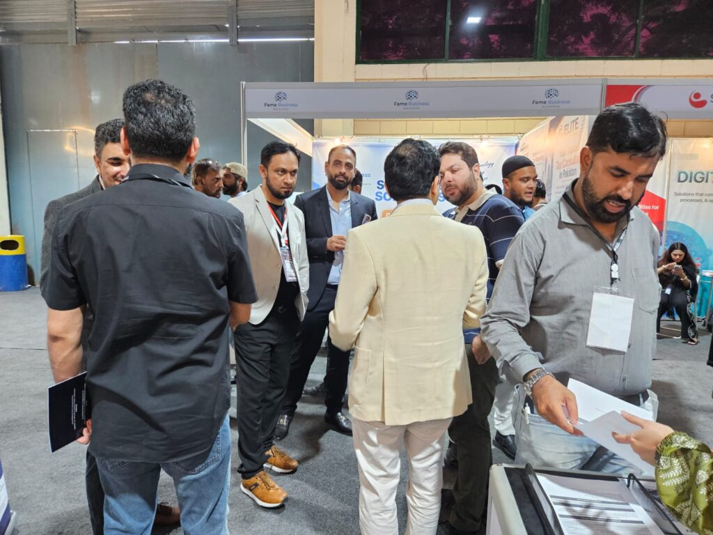 Visitors holding brochures at the Sherdil IT Academy stand, ITCN Asia 2026